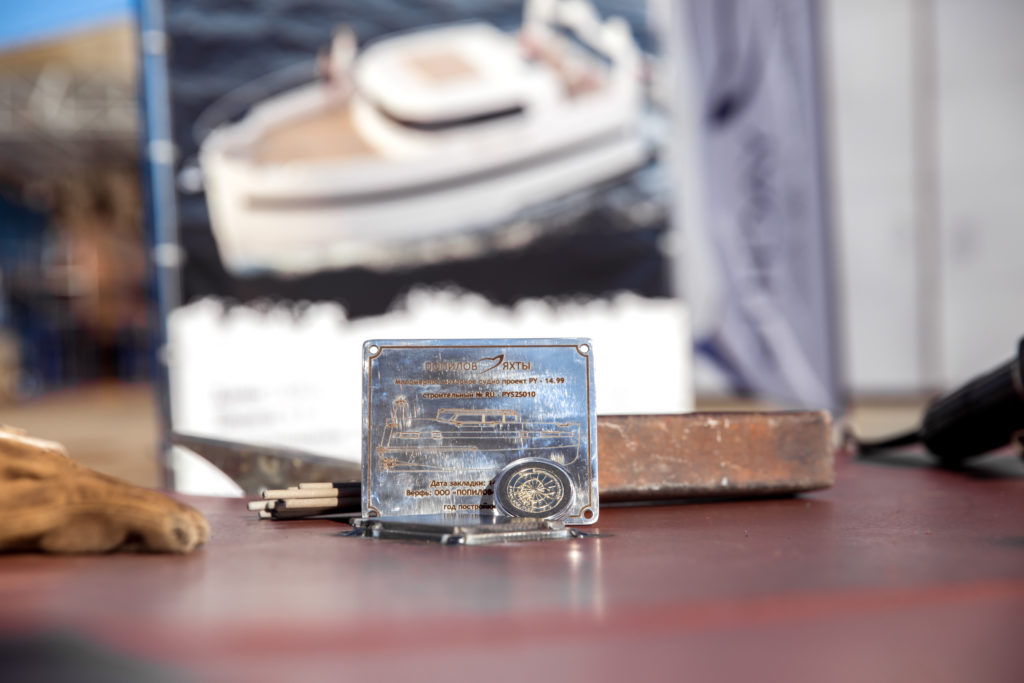 Закладная табличка и монета стальной моторной яхты